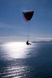 fly;flying;flies;soar;soaring;paraglide;paraglides;paragliders;paragliding;parapont;paraponts;paraponter;paraponters;paraponting;parasail;parasails;parasailer;parasailers;parasailing;cliff;bluff;jump;sea;ocean-sunlight;glare