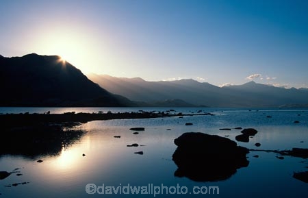 lake;lake-wanaka;reflection;still;stillness;water;tranquil;tranquility;peaceful;calm;sunrise;haze;hazy;sun-ray;sun-rays;sun-beam;sun-beams;silhouette;silhouettes;silhouetted