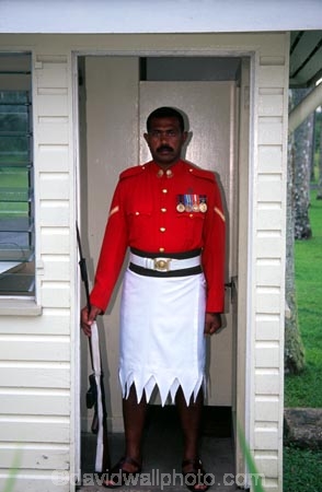 guard;guarding;stand;standing;uniform;red;white;shirt;belt;medal;medals;doorway;headquarters