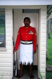 guard;guarding;stand;standing;uniform;red;white;shirt;belt;medal;medals;doorway;headquarters
